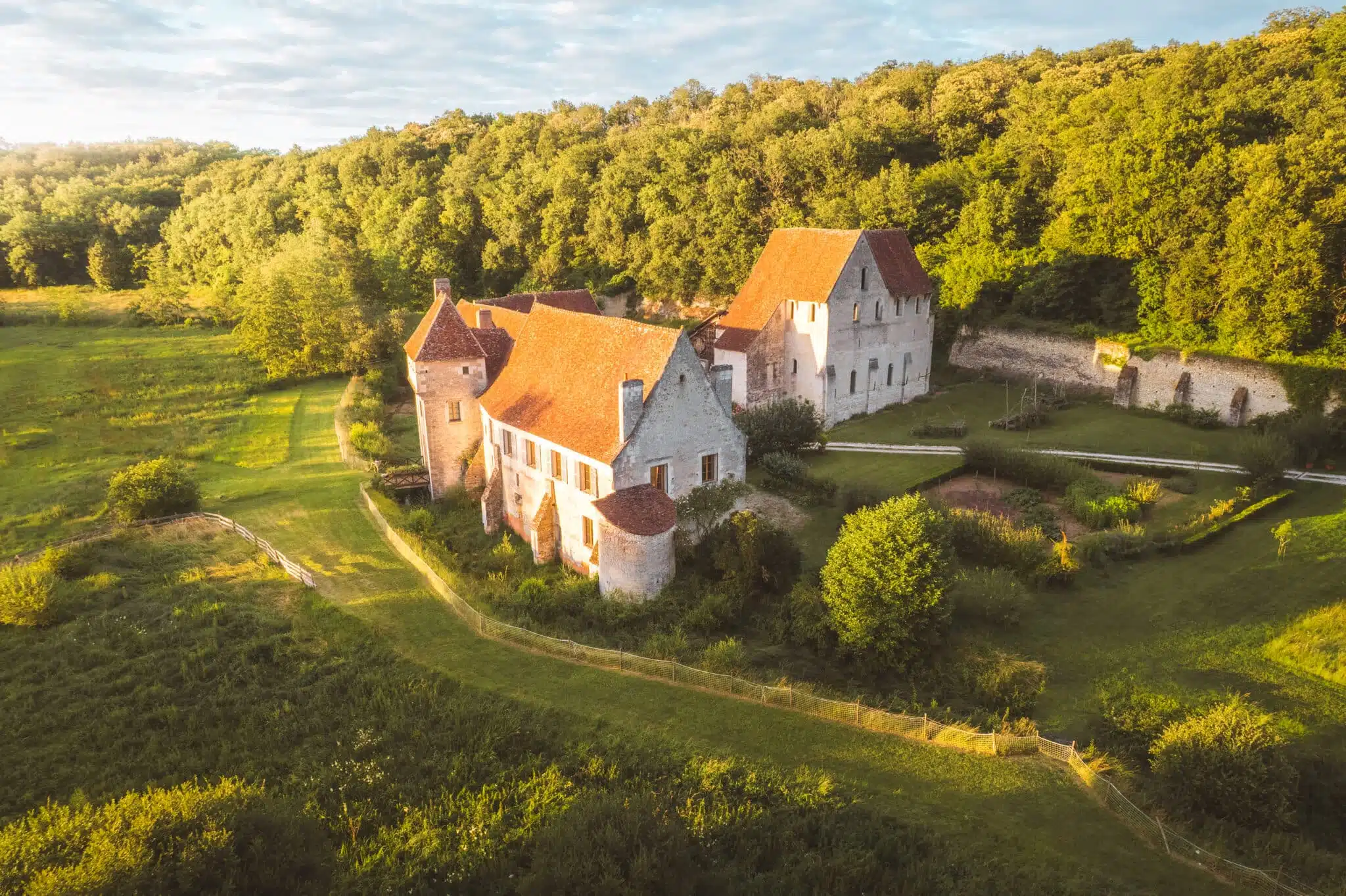 Château-monastère de la Corroirie dans son paysage de Touraine au coucher du soleil